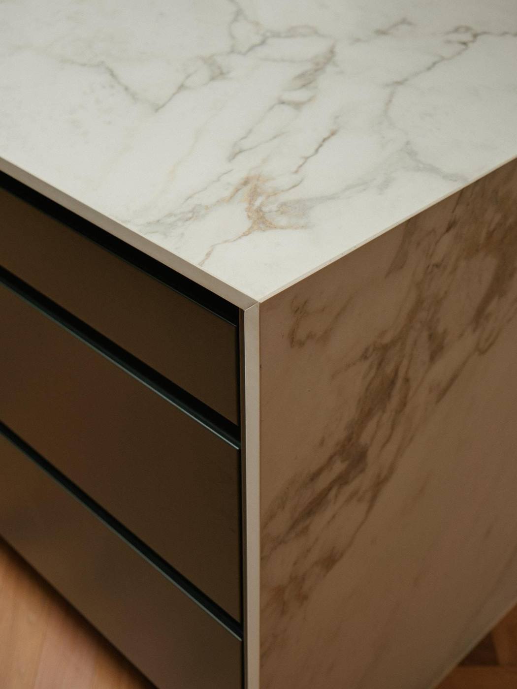 Kitchen island in marble and bronze with a fluted edge